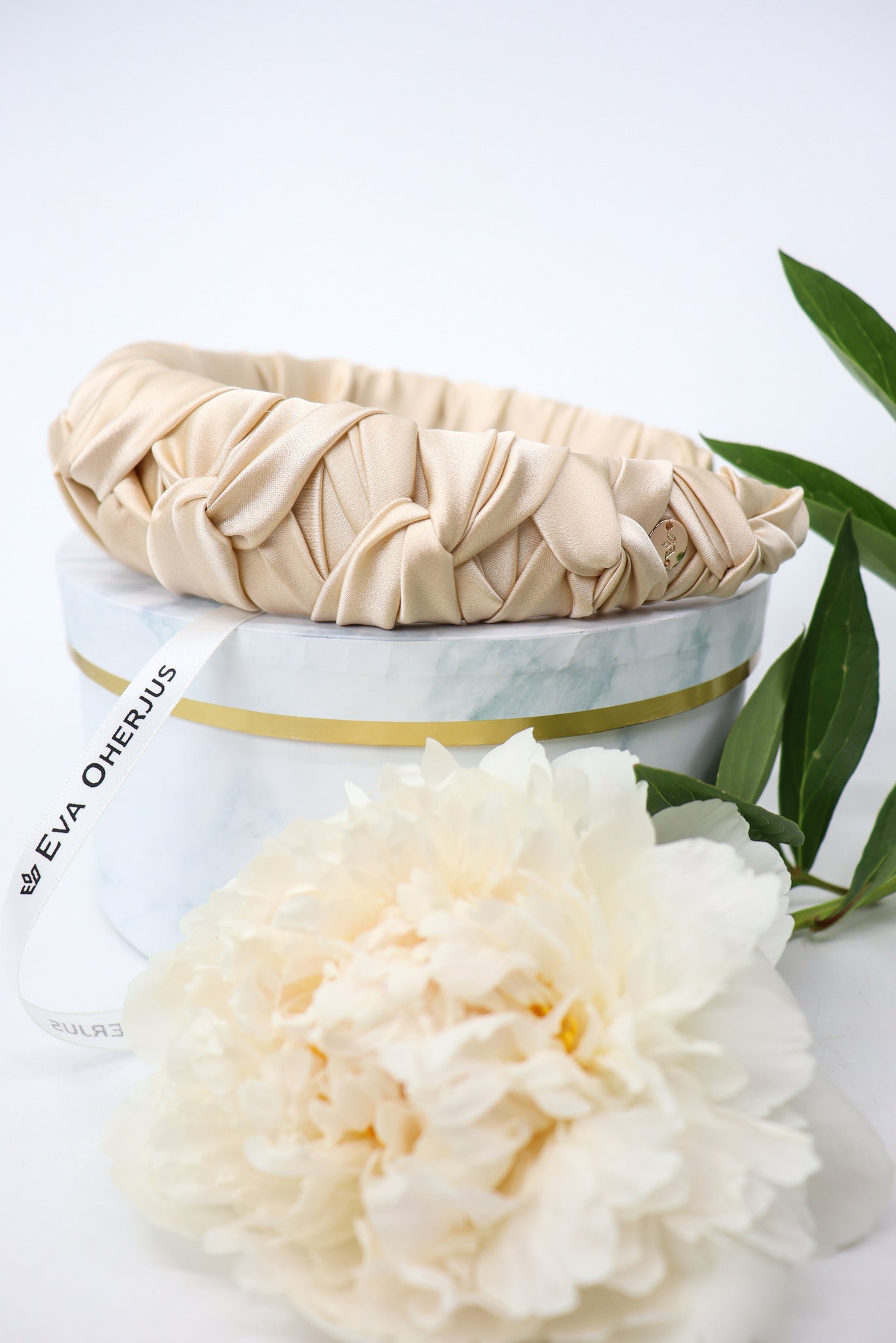 Side view of Jenna light beige silk headband, highlighting the slightly padded braiding technique for added volume without excessive height.