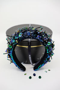 Maria Extra High Sequin Crown by Eva Oherjus- Embrace elegance in green & blue sequins, adorned with shimmering crystals & beads. Hand-sewn tulle and golden accents elevate this regal headpiece.