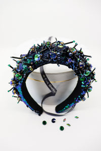 Maria Extra High Sequin Crown by Eva Oherjus- Embrace elegance in green & blue sequins, adorned with shimmering crystals & beads. Hand-sewn tulle and golden accents elevate this regal headpiece.